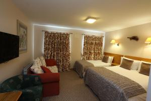 a hotel room with two beds and a couch at The Keepers Arms in Ballyconnell