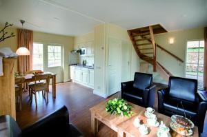 a living room with a table and chairs and a kitchen at Erve Woolderink in Wierden