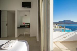 a bedroom with a view of the ocean from a balcony at Kaladi Rock in Avlemonas