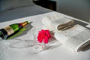 a bottle of champagne and a rose on a bed at Kaladi Rock in Avlemonas