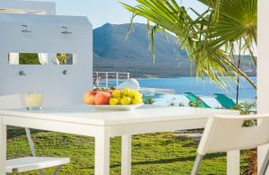 a white table with a bowl of fruit on it at Kaladi Rock in Avlemonas