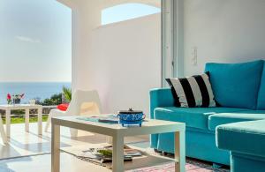 a living room with a blue couch and a table at Kaladi Rock in Avlemonas