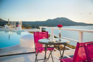 a table with a vase of flowers and two chairs at Kaladi Rock in Avlemonas