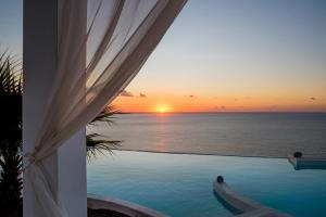 a view of the ocean from a pool with a sunset at Kaladi Rock in Avlemonas