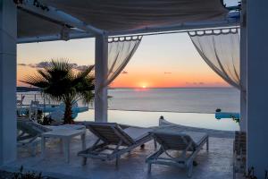 a patio with chairs and a pool with a sunset at Kaladi Rock in Avlemonas
