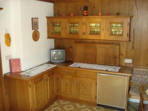a kitchen with wooden cabinets and a tv on a counter at Gästehaus Sillaber-Gertraud Nuck in Söll