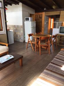 a living room with a table and chairs and a refrigerator at CABAÑA ÚNICA in Miramar