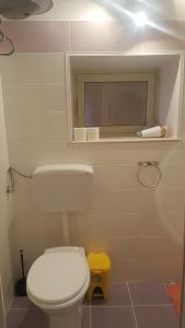 シラクーサにあるRoom Calafatariのバスルーム(白いトイレ、黄色いスツール付)