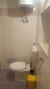 シラクーサにあるRoom Calafatariのバスルーム(白いトイレ、黄色いゴミ箱付)