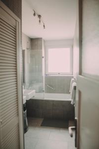 a bathroom with a tub and a sink and a window at Globetrotter in Zagreb