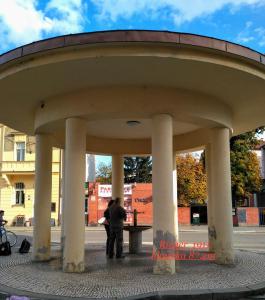 dos personas de pie bajo un gran edificio con columnas en Homestay Poděbrady, en Poděbrady