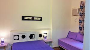 Un dormitorio con camas moradas y un sofá púrpura. en Apartamento Lausanne, en Río de Janeiro