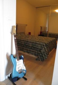 una guitarra azul está de pie junto a una cama en Apartment Andrija, en Baška Voda
