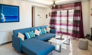 アテネにあるLeo - Unique Glyfada Apartmentのリビングルーム(青いソファ、テーブル付)