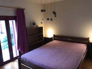 エルムポリにあるErmoupoli, Syros City Apartmentsのベッドルーム1室(紫のシーツが敷かれた大型ベッド1台付)