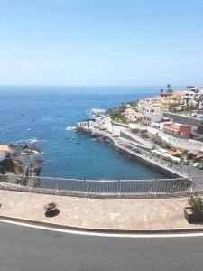 een uitzicht op de oceaan en een strand met gebouwen bij Apartamento Playa Chica in Puerto de Santiago