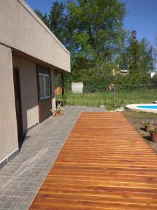 una pasarela de madera que conduce a una casa con piscina en Casa quinta Camino al Sol en Junín