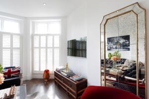 ein Wohnzimmer mit einem großen Spiegel und einem roten Sofa in der Unterkunft Primrose Boutique Home in London