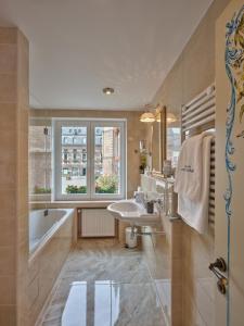 La salle de bains est pourvue d'un lavabo, d'une baignoire et d'une fenêtre. dans l'établissement Apartment-Hotel am Rathaus, à Düsseldorf