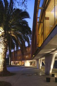 a building with a palm tree in front of a building at Las Majadas Hotel & Centro de Reuniones in Pirque