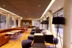 a lobby with couches and tables and chairs at Las Majadas Hotel & Centro de Reuniones in Pirque