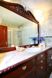 ein Badezimmer mit einem Waschbecken und einem großen Spiegel in der Unterkunft Villa Dallas Residence - Airport shuttle in Warna