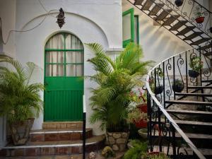 una puerta verde al lado de un edificio con plantas en Serena Vista, en Álamos