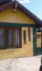 un edificio amarillo con ventanas laterales en La Casa De La Abuela Departamentos en El Bolsón