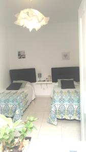 1 Schlafzimmer mit 2 Betten und einem Kronleuchter in der Unterkunft Apartamento Anaca in Playa Blanca