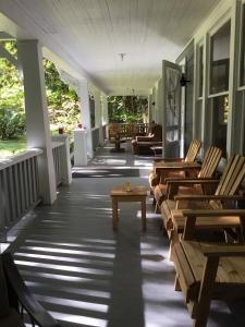 een veranda met stoelen en tafels in een huis bij Mountain Meadows Inn & Chalet Suites in Ashford