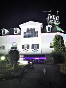 un bâtiment blanc avec un panneau sur lui la nuit dans l'établissement Pal Annex Yamaguchi (Love Hotel), à Iwakuni