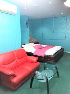 a bedroom with a bed and a couch and a table at Pal Annex Yamaguchi (Love Hotel) in Iwakuni