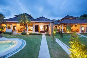 a house with a swimming pool in front of it at Bali Dyana Villas in Seminyak