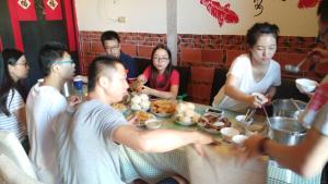 金寧鄉的住宿－雙鯉風晴古厝民宿，一群坐在桌子旁吃食物的人