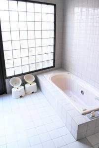 a white bathroom with two toilets and a tub at Hotel Pal Furugou (Love Hotel) in Oita