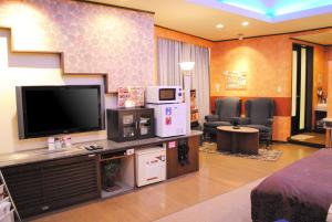 a living room with a flat screen tv and chairs at Hotel Pal Furugou (Love Hotel) in Oita