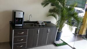 a kitchen with a sink and a coffee machine at Mass Hotel in Kampong Kerayong