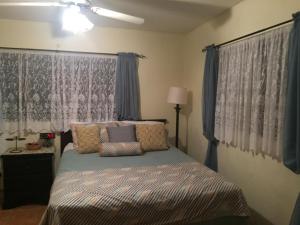 1 dormitorio con 1 cama con cortinas azules en Sagusta Gardens NCA, en NCA