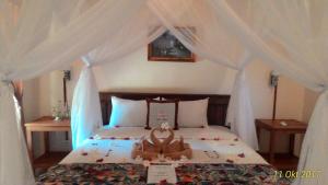 a bedroom with a bed with white drapes at Pande Guest House in Pemuteran