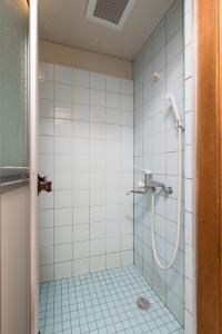 a bathroom with a shower with white tiles at Yukiya in Osaka +47 photos