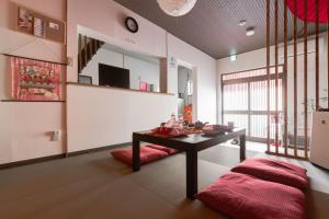 a living room with a table and red cushions at Yukiya in Osaka