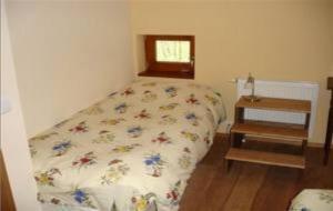 ein Schlafzimmer mit einem Bett und einem kleinen Fenster in der Unterkunft Ferme Auberge du Moulin des Sept Fontaines in Drachenbronn