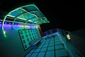 a building with green and blue lights on it at Hotel Lemon Stay in Yercaud