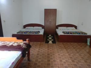 a room with two beds in a room at The Shades Holiday inn in Kushālnagar