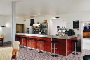 a bar in a restaurant with stools at Hôtel de France in Saint-Savin-sur-Gartempe