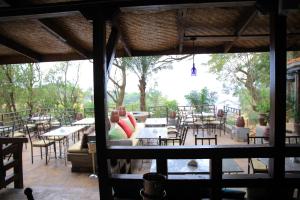 a view of a patio with tables and chairs at Kampala Forest Resort - KFR Lodge in Kampala