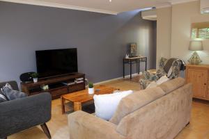 een woonkamer met een bank en een flatscreen-tv bij Annie's Place in Cowes