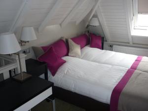 a bedroom with a large bed with purple pillows at In den Verdwaalde Koogel in Heusden