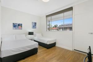 1 dormitorio con 2 camas y ventana en Australian Community Villages en Bankstown