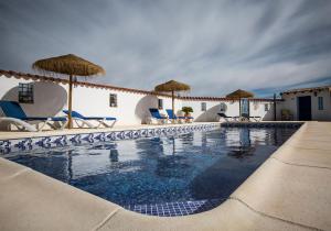 a swimming pool with chairs and umbrellas at B&B Casa Luna Vélez Blanco in Vélez Blanco